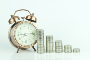 stacked of coins and alarm clock on white background , concept in growth, save and investment in business