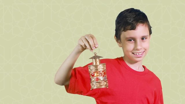 Happy Muslim Kid in Ramadan - Muslim boy celebrating Ramadan - playing with Ramadan lantern in front of Islamic background