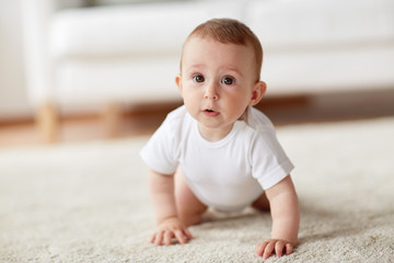 little baby in diaper crawling on floor at home