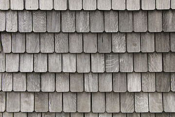 Fragment of the roof of the old house consisting of small square gray plates.