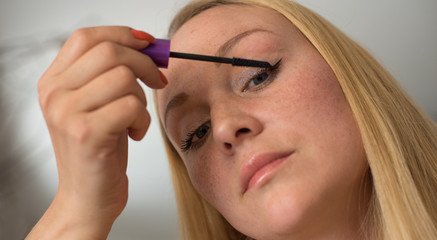 Eye makeup.Young woman applying mascara make-up