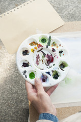 The artist holds a palette in hand