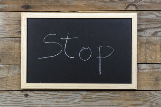 Space chalkboard background texture with wooden frame with the word "Stop". blackboard space for wallpaper. Landscape mounting style horizontal.
