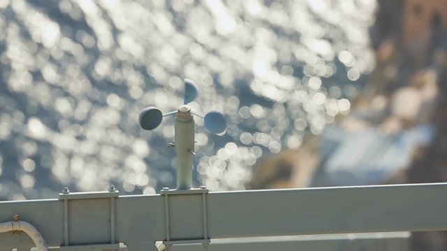 Cup anemometer rotating to measure wind speed at seaside, weather forecast