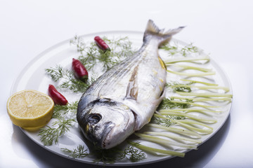 bream topped on a white plate ready to be cooked