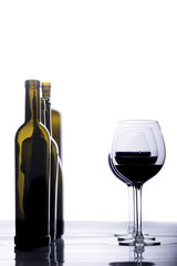 bottle and crystal glass with red wine, on white background