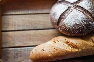 Black and white bread on a wooden background. Rye bread with butter. Dark bread and baguette with onions. and dill