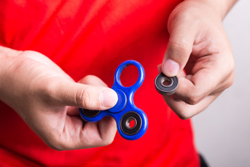 Person holding dislodged weight from fidget spinner, dangerous for kids