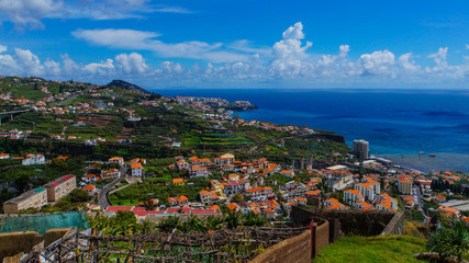 Fototapeta na wymiar Madeira - Fisherman village camara de Lobos from Miradouro de Torre with blue ocean and houses and industry