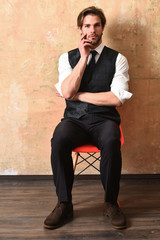 serious fashion business man sitting on chair