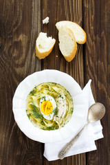 Homemade chicken soup with noodles and egg.