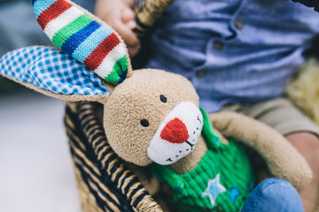 Sweet teadybear of a little baby boy playing with his toys in the park outdoors. Lifestyle portrait.