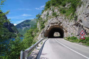 Road tunnel in the rock. Highway tunnel cutting through a mountain. Montenegro, Lake Piva