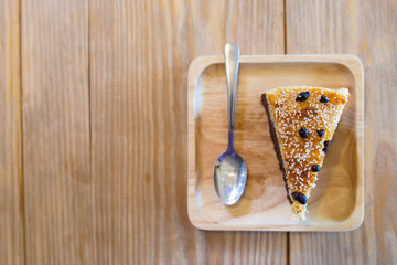 Chocolate cake topping with coconut flake and chocolate  chip on wooden tray and wooden table with flaring