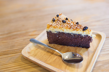 Chocolate cake topping with coconut flake and chocolate  chip on wooden tray and wooden table