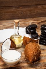 Oil, coconut and stones for a massage on  wooden background