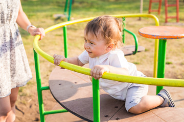 Fototapeta na wymiar Cute young child boy or kid playing on playground.