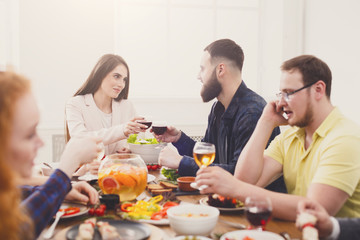 Group of happy young people at dinner table, friends party