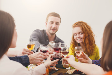 Group of happy young people at dinner table, friends party