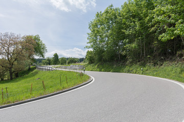 Fototapeta na wymiar Kurve am Waldrand auf Strasse- strassenverlauf 