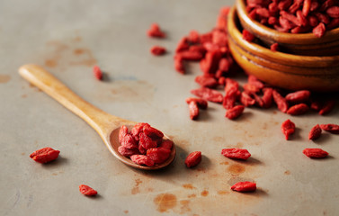 Dried goji berries on a wooden spoon
