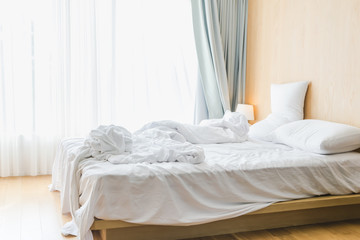 Bed sheets and pillows messed up after nights sleep ,comfort and bedding concept in a hotel room, concept travel and vacation