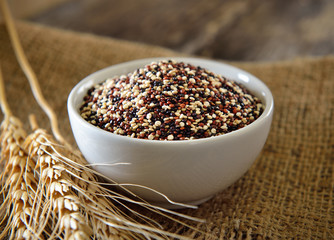 Quinoa seeds in bowl on wood