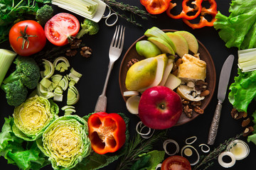 Eating healthy vegetable food on black background.