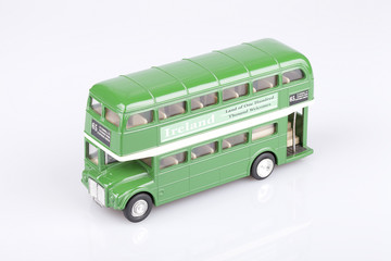 Irish double decker toy on a white surface. Ireland green bus isolated on white background.