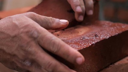 Strong man's hands building a house
