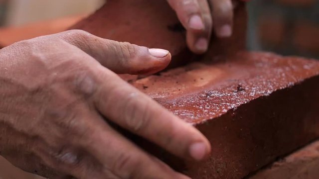 Strong man's hands building a house