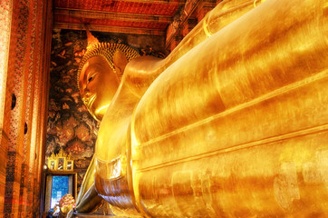 Travel and vacation. Reclining Buddha gold statue. Wat Pho, Bangkok, Thailand.