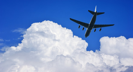 Airplane silhouette in deep blue sky.