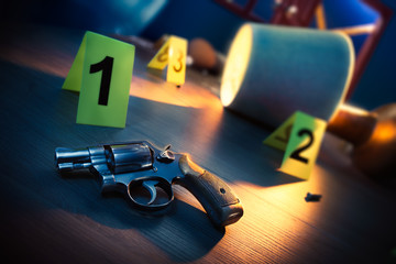 dramatic lit crime scene with gun and markers on the floor