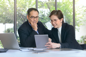 Businessman and businesswoman discussing and working together during a meeting in office