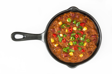 Traditional mexican tex mex chili con carne in a frying pan isolated on white background
