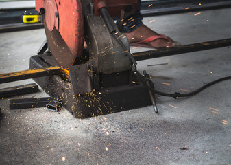worker cutting iron tube with steel cutter