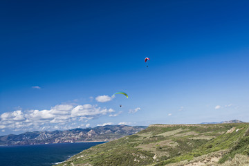 Fototapeta na wymiar Paragliding in blue cloudy sky