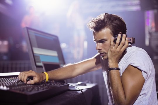 Young Male DJ Performing At Nightclub