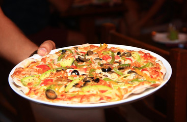 Pizza with black olives, tomato, pepper and cheese on a plate, food photo