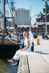 Beautiful asian bride and manful european groom walking on old town near the sea. Wedding concept for your design or magazine