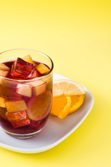 Sangria drink in glass on yellow background
