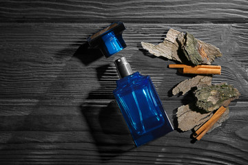 Composition with modern male perfume on dark wooden background