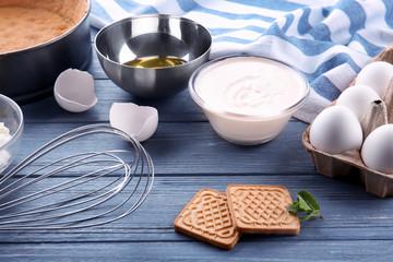 Ingredients for tasty cheesecake on wooden table