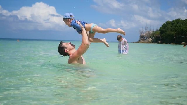a guy with kid plays having fun in the sea.Snorkelling