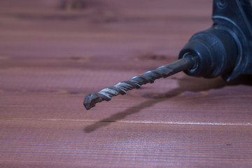 Hammer drill on a wooden background. Close-up. The electric tool