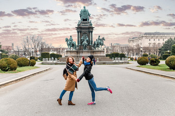 Two happy woman friends meeting and hugging in Europe city, friendship and travel concept