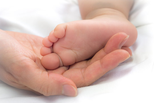 close-up feet of baby in the hand of mother.