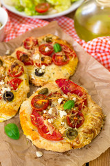 Mini pizzas with thick crust with tomato and feta cheese