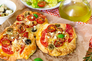 Mini pizzas with thick crust with tomato and feta cheese